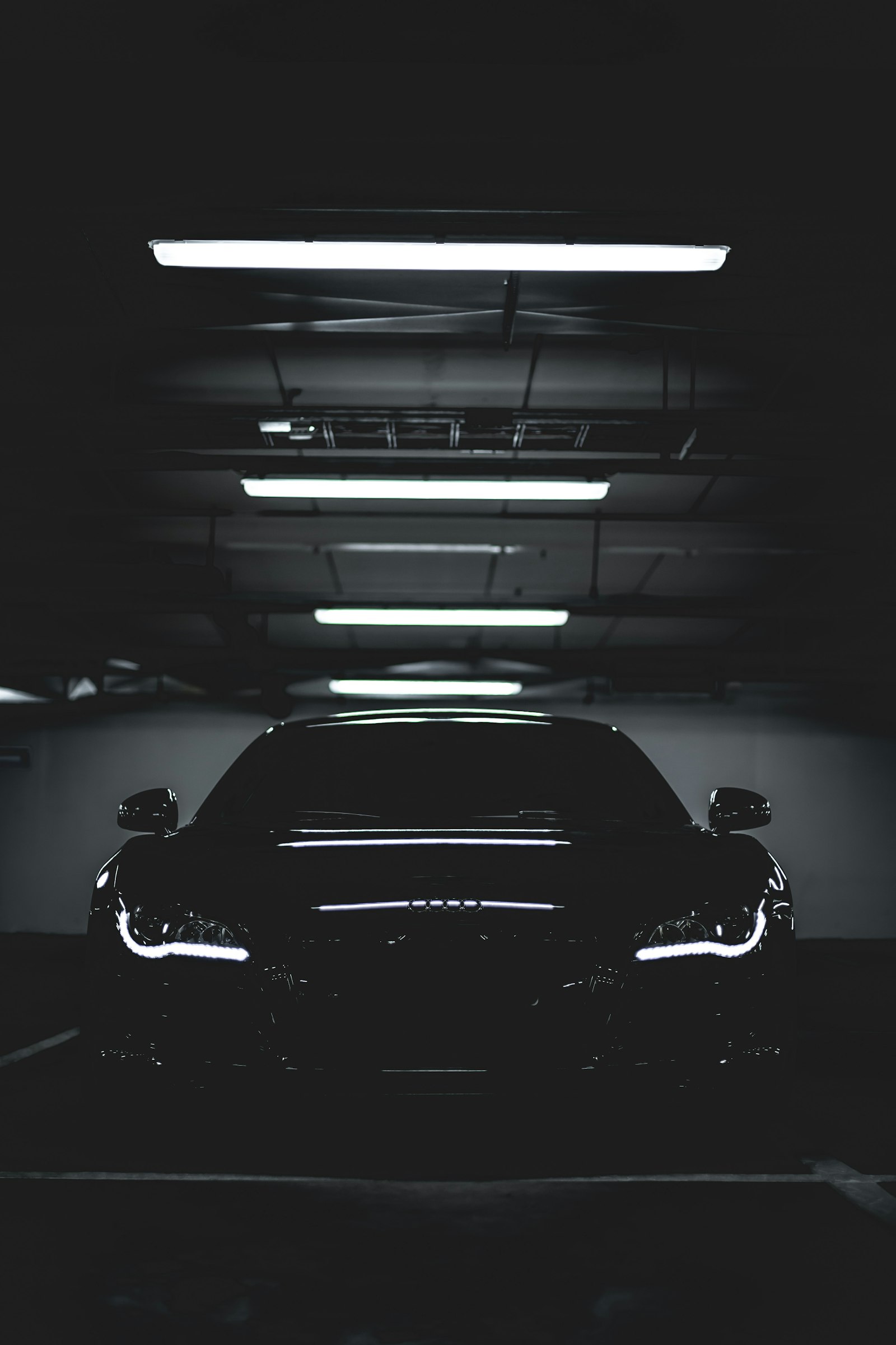 Black luxury sports car in a dark garage